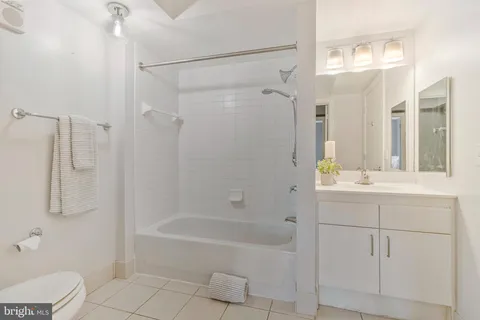 a bathroom with a granite countertop sink a toilet and shower