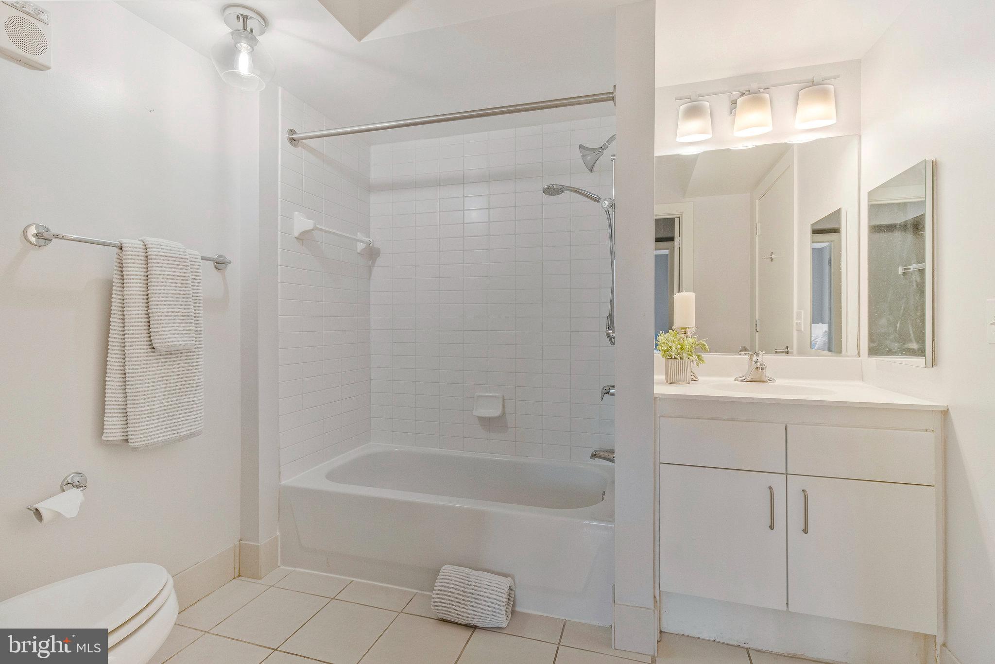 1000 New Jersey Avenue Southeast, Unit 914 Washington, DC 20003 - Photo 28 of 48 a bathroom with a granite countertop sink a toilet and shower