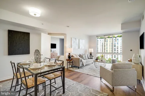 a living room with furniture kitchen view and a large window