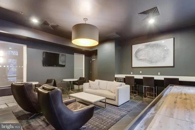 a living room with furniture a lamp and a rug