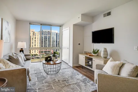 a living room with furniture a flat screen tv and a large window