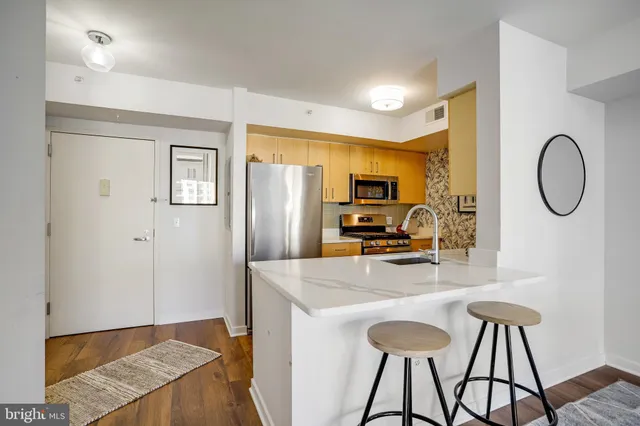 a kitchen with stainless steel appliances granite countertop a refrigerator and a stove top oven