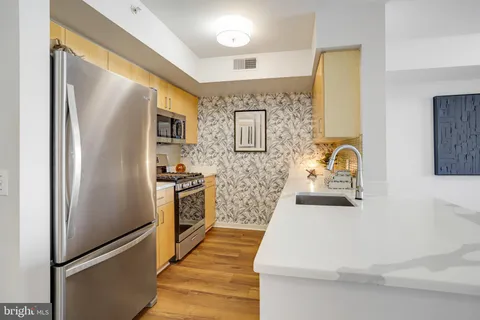 a kitchen with stainless steel appliances granite countertop a refrigerator and a sink