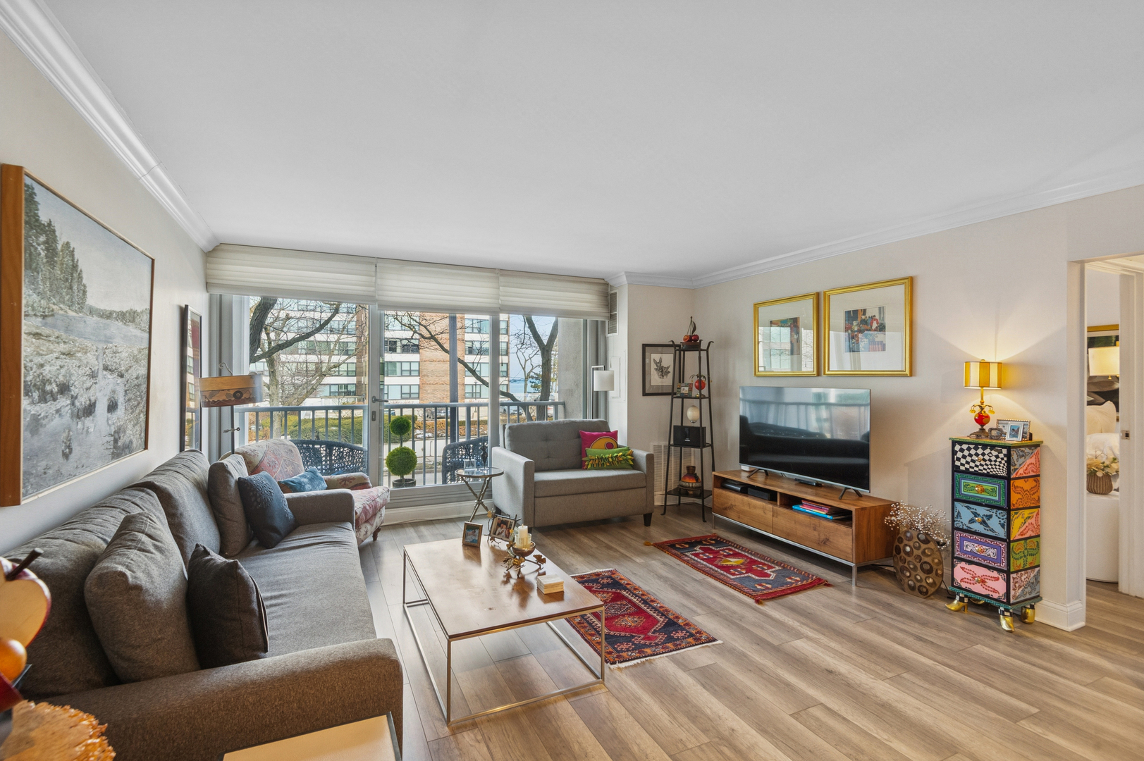 1625 Sheridan Road, Unit 204 Wilmette, IL 60091 - Photo 2 of 16 a living room with furniture a flat screen tv and a floor to ceiling window