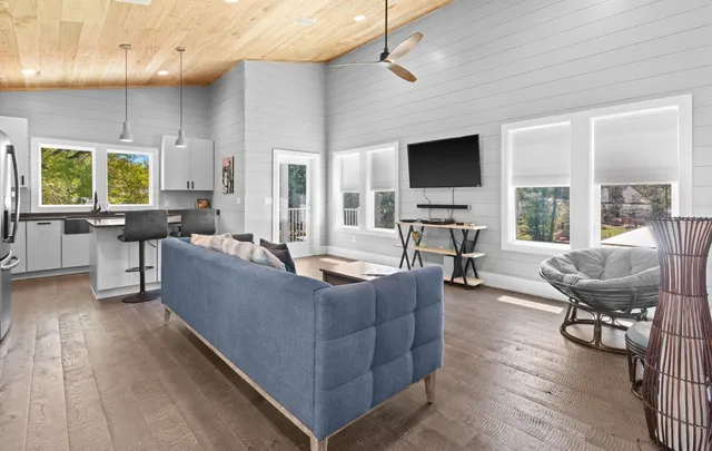 a living room with furniture flat screen tv and a large window