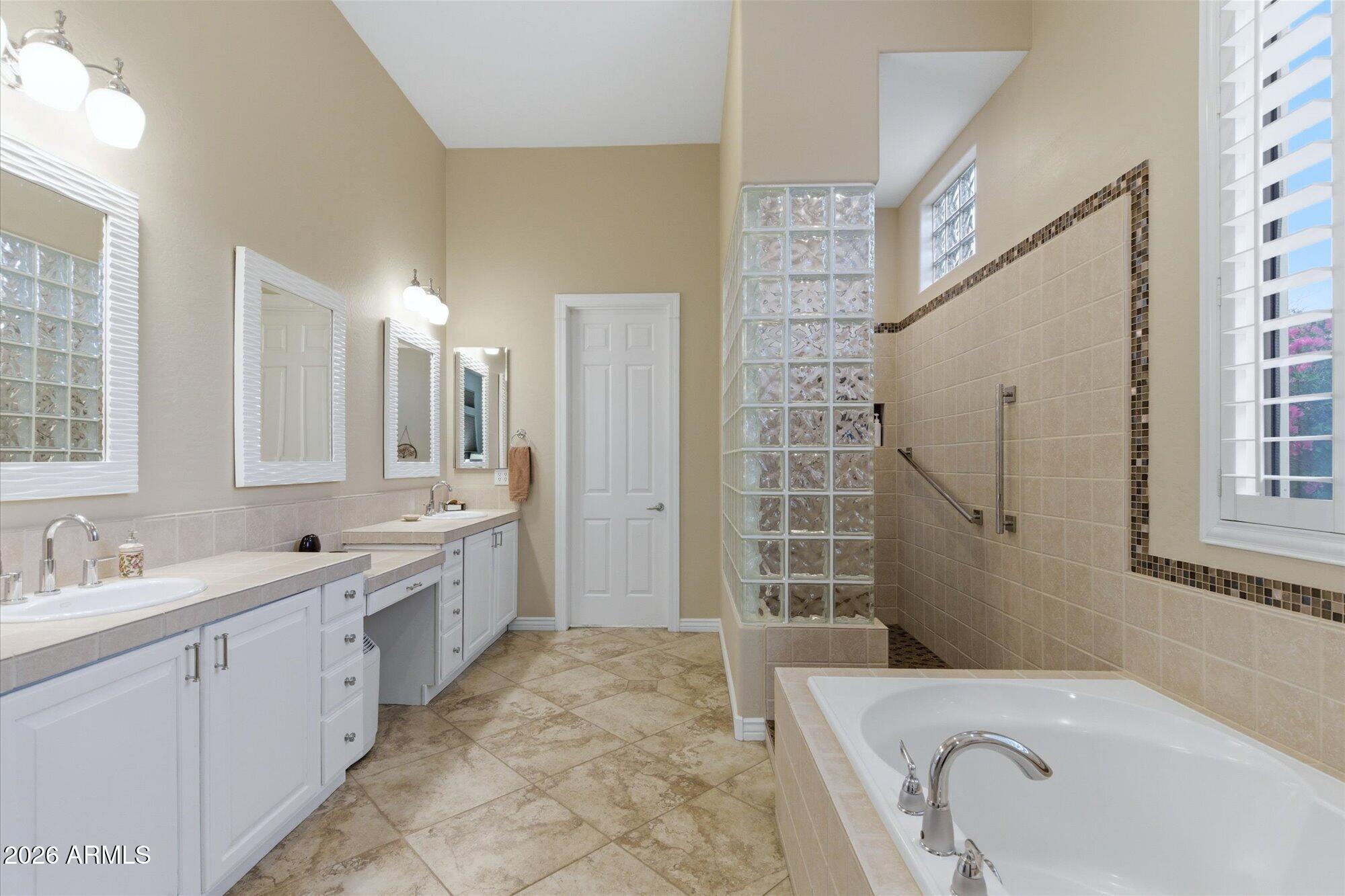 40322 North Hawk Ridge Trail Anthem, AZ 85086 - Photo 31 of 63 a bathroom with a tub sink and mirror