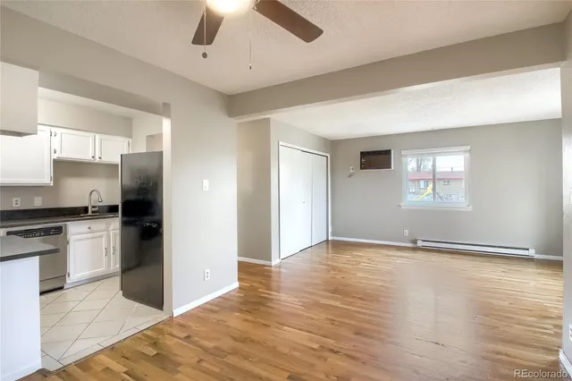 a view of an empty room with window and wooden floor