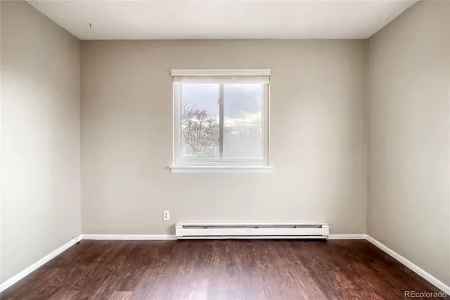 an empty room with wooden floor and a window