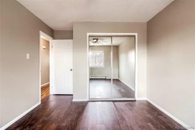an empty room with wooden floor & wooden door