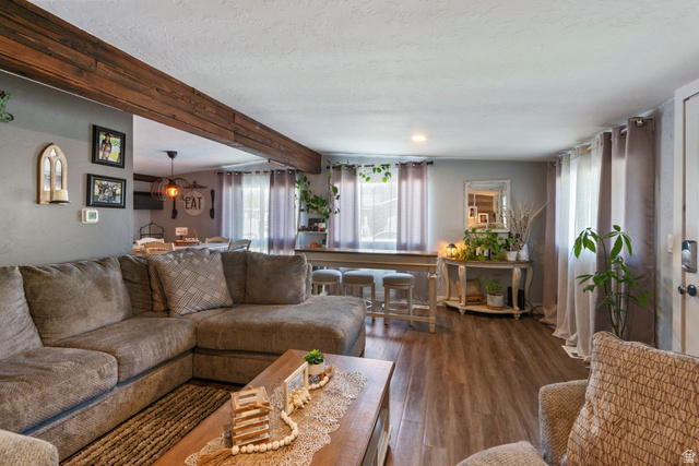 255 North 1600 West, Unit 60 Provo, UT 84601 - Photo 2 of 22 Living room featuring beamed ceiling, dark wood-type flooring, plenty of natural light, and a textured ceiling