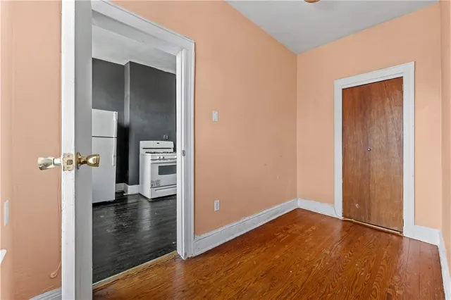 an empty room with wooden floor and a bathroom