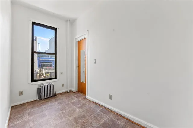 an empty room with windows and closet