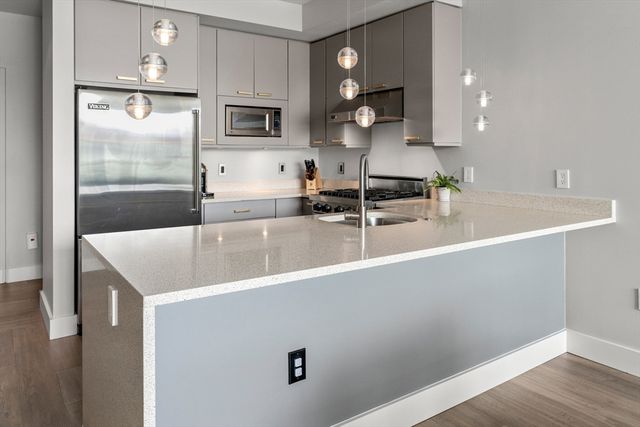 a kitchen with a sink a counter space and cabinets