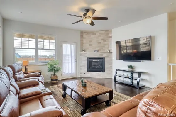 a living room with furniture a flat screen tv and a fireplace