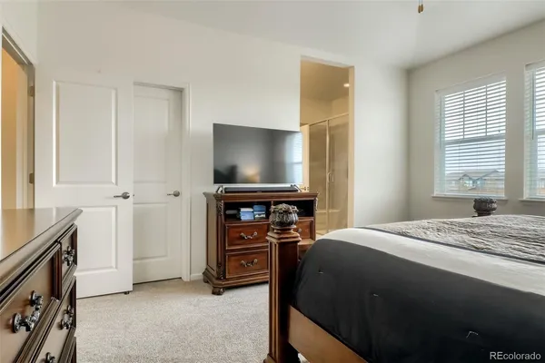 a bedroom with a bed and a flat tv screen on dresser
