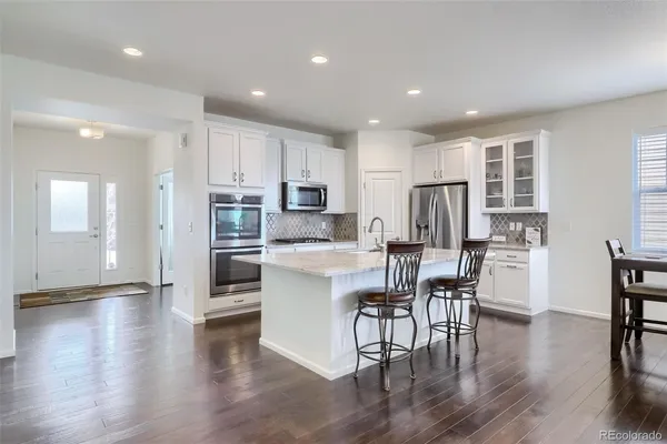 a kitchen with a table chairs refrigerator microwave and cabinets