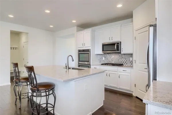 a kitchen with stainless steel appliances a stove a sink a microwave a refrigerator and cabinets