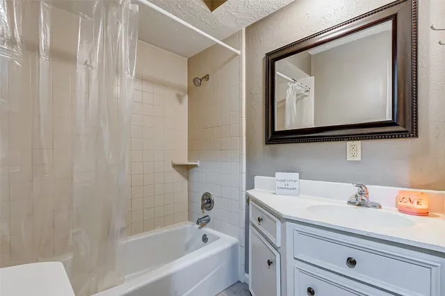 a bathroom with a tub sink and mirror