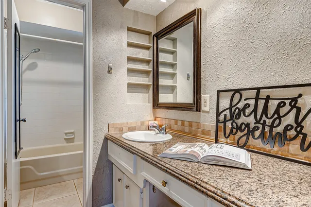 a bathroom with a granite countertop sink and a mirror
