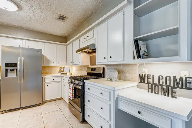 a kitchen with white cabinets and stainless steel appliances