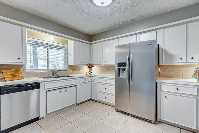 a kitchen with a refrigerator sink and cabinets