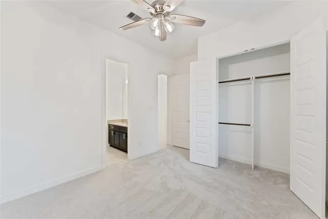 an empty room with closet and windows