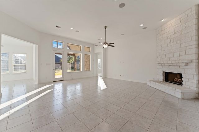 a view of an empty room with a fireplace and a window