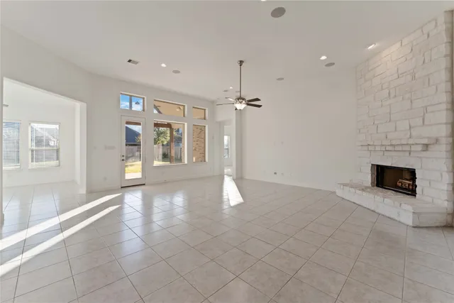 a view of an empty room with a fireplace and a window
