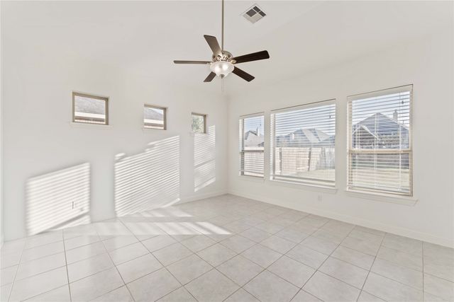 a view of empty room with window and ceiling fan