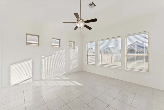 a view of empty room with window and ceiling fan