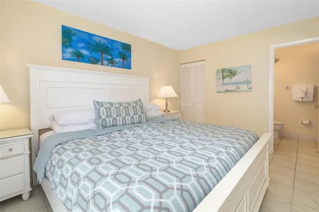 a bedroom with a bed and a painting on the wall