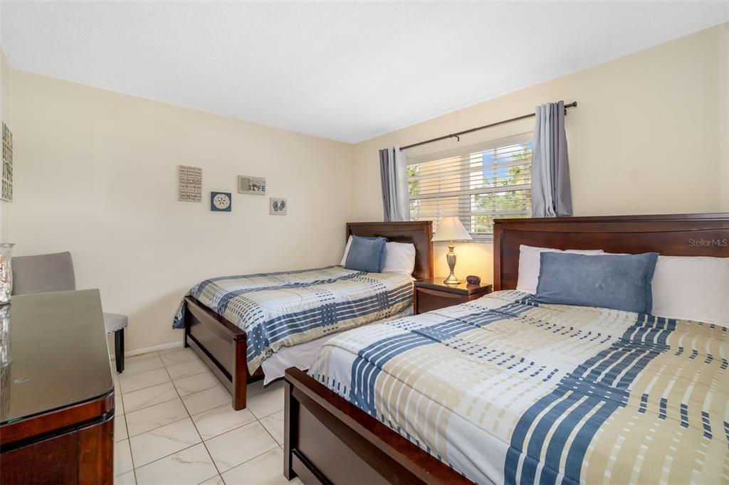 5961 Midnight Pass Road, Unit 319 Sarasota, FL 34242 - Photo 16 of 34 a bedroom with two beds and a large window