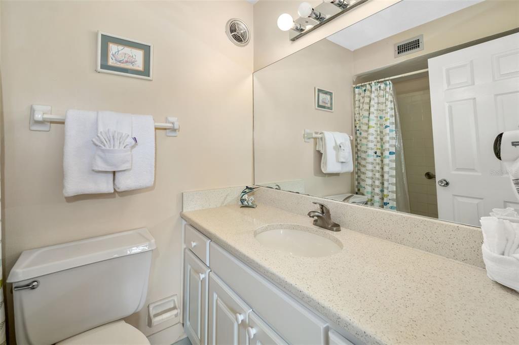 5961 Midnight Pass Road, Unit 319 Sarasota, FL 34242 - Photo 18 of 34 a bathroom with a granite countertop sink mirror vanity and toilet