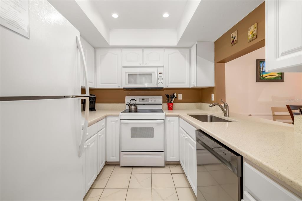 5961 Midnight Pass Road, Unit 319 Sarasota, FL 34242 - Photo 5 of 34 a kitchen with a sink cabinets and appliances