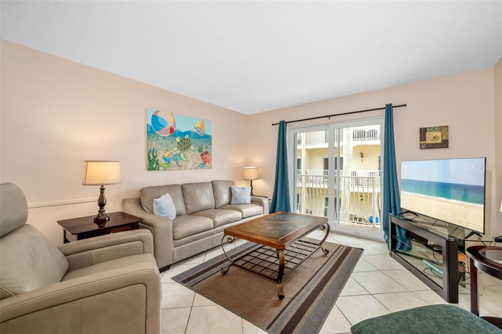 5961 Midnight Pass Road, Unit 319 Sarasota, FL 34242 - Photo 9 of 34 a living room with furniture and a flat screen tv