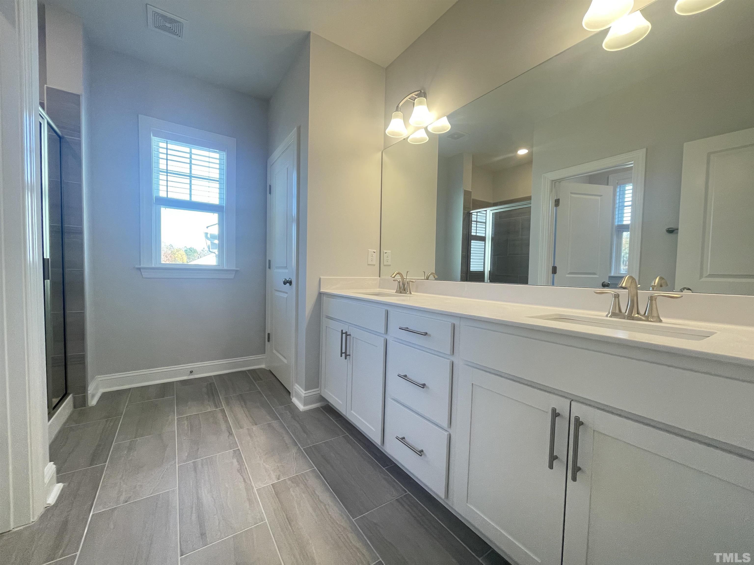 191 Edge Of Auburn Boulevard Raleigh, NC 27610 - Photo 14 of 24 a spacious bathroom with a double vanity sink and mirror