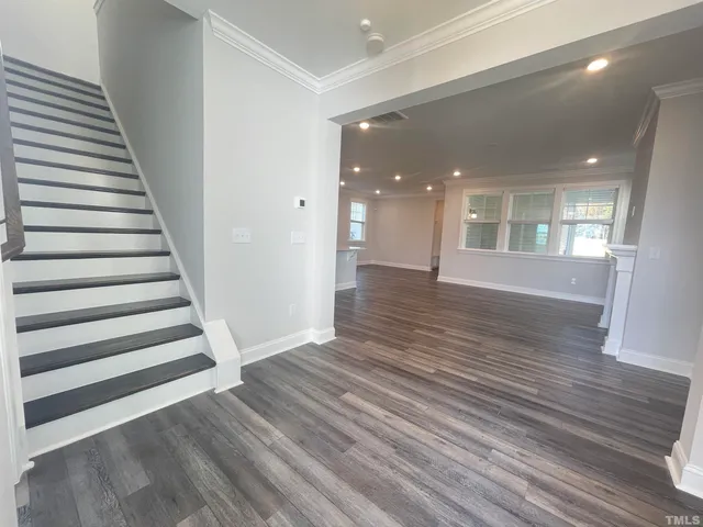 a view of a room with wooden floors and stairs