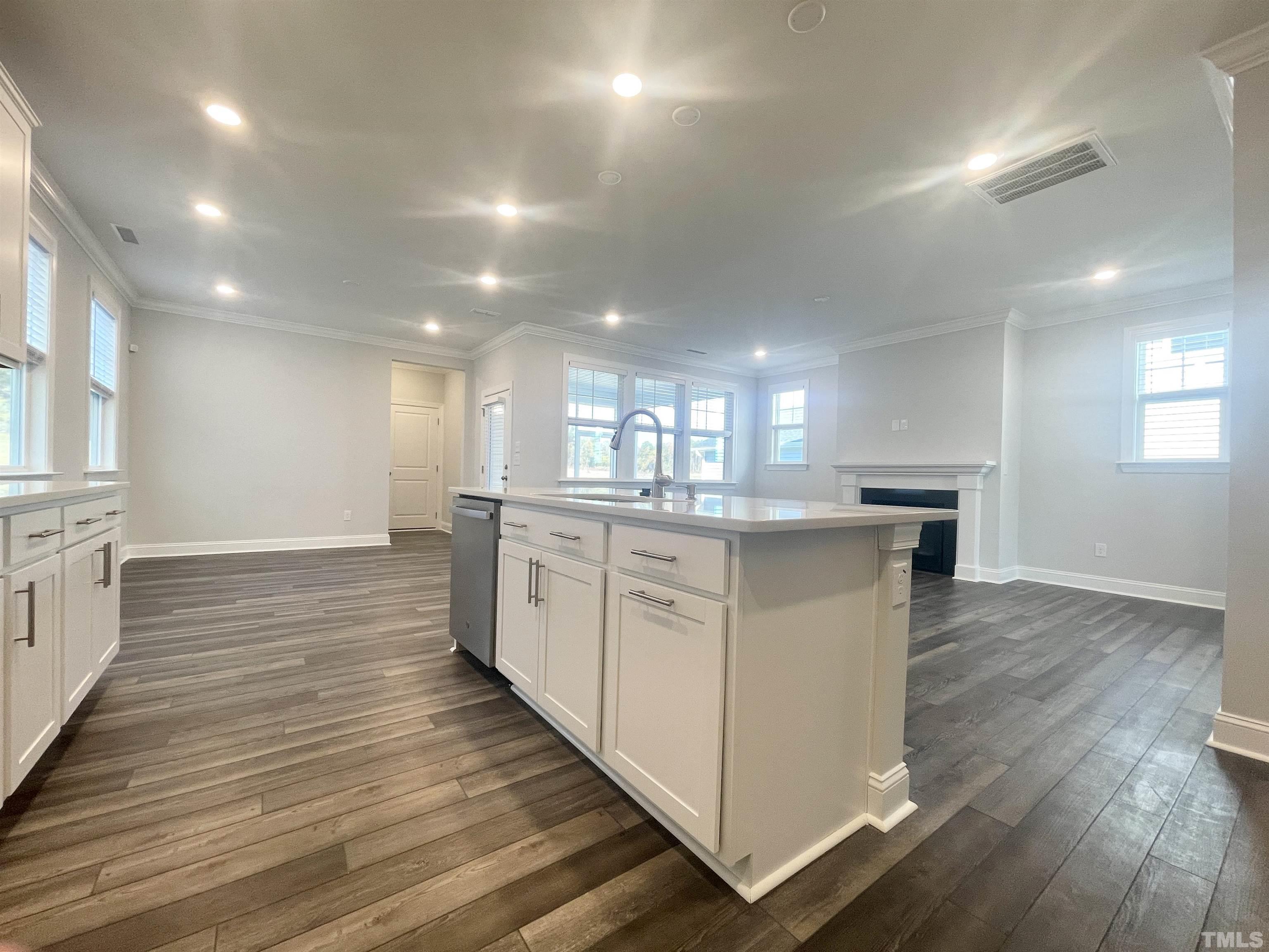 191 Edge Of Auburn Boulevard Raleigh, NC 27610 - Photo 5 of 24 a large kitchen with kitchen island a sink wooden floor and stainless steel appliances