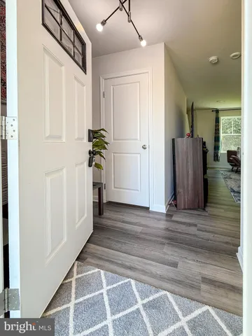 a view of a hallway with wooden floor and windows
