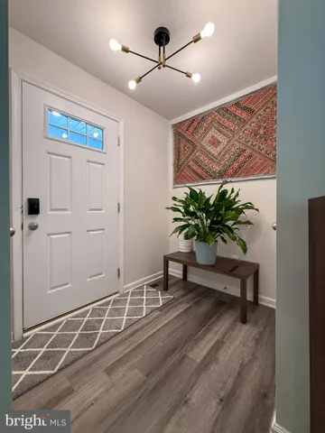 a view of a hallway with wooden floor and a potted plant