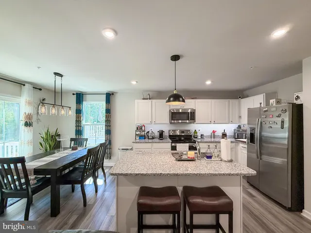 a kitchen with refrigerator and chairs
