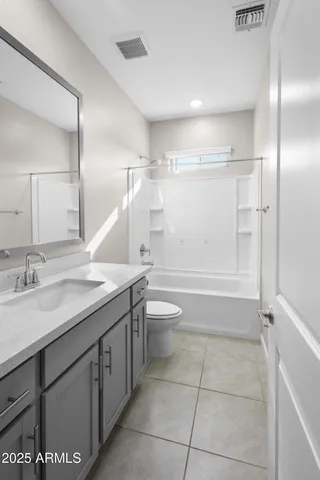 a bathroom with a granite countertop sink a toilet a mirror and shower