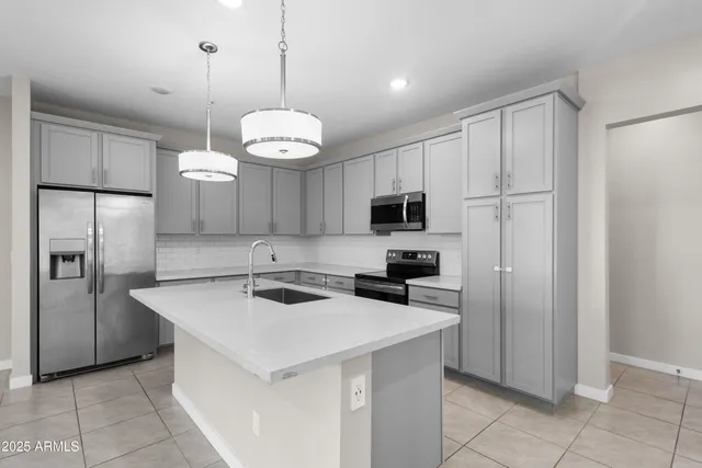 a kitchen with kitchen island a counter space cabinets and stainless steel appliances
