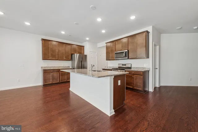 a kitchen with stainless steel appliances kitchen island granite countertop a stove a sink and a microwave