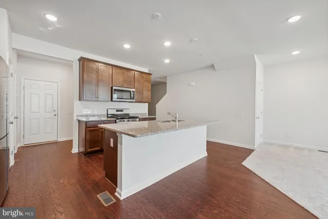a large kitchen with kitchen island a sink stainless steel appliances and cabinets