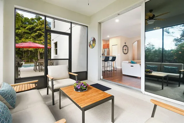 a living room with furniture a table and a large window