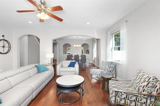 a living room with furniture a fireplace and a chandelier