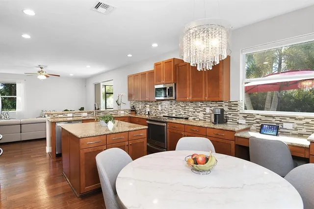 a kitchen with a sink a stove a dining table and chairs