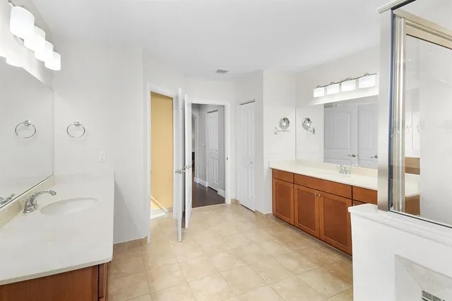 a large bathroom with a tub sink and mirror