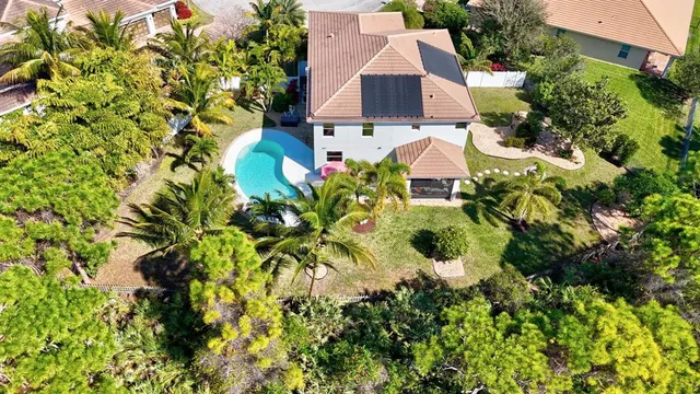 an aerial view of residential house with swimming pool and lawn chairs